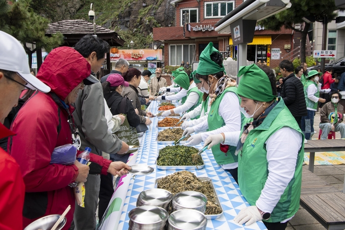 ▲ 울릉군새마을부녀회(회장 박명숙)는 지난 24일 도동항 소공원(해변공원)에서 울릉도를 찾은 관광객을 대상으로 ‘울릉 향토나물 시식회’를 열고, 울릉도의 청정 자연이 빚어낸 산나물 먹거리를 선보였다고 26일 밝혔다. 사진 울릉군