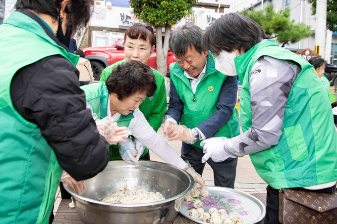 ▲ 남한권 울릉군수를 비롯해 박명숙 새마을부녀회장 등 부녀회원들이 울릉도 자생 산나물인 참고비, 삼나물, 부지갱이, 미역취, 더덕, 명이 등을 직접 볶고 무쳐 관광객에게 제공하며, 향토의 맛과 향을 전했다. 사진 울릉군