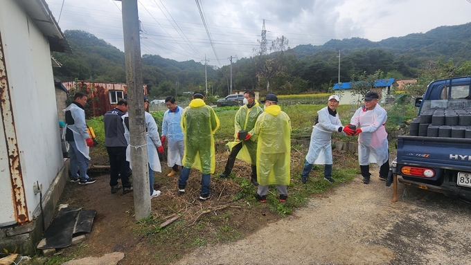 ▲ 한상백 회장(가운데)과 구미불교거사림회원들이 지난 25일 고아읍 대망2리 강 모 어르신 댁에 ‘사랑의 연탄’을 배달하고 있다.