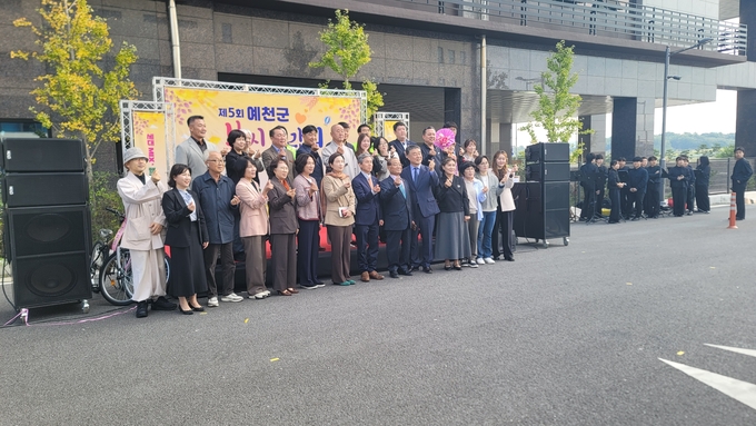 ▲ 예천군이 25일 호명읍 예천군복합커뮤니티센터 주차장에서 ‘제5회  복지박람회’를 성황리에 개최하고 김종현 지역사회보장협의체 민간위원장과 황은정 예천군사회복지사협회장 등 참석 관계자들이 모여 손가락 하트 모양을 하며  기념촬영을 하는 장면,예천군 제공