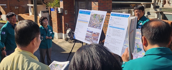 ▲ 27일 오전 예천군의회 의원들이 백전리 취약개선 생활여건 개조사업 현장을 방문해 박호숙 도시과장으로부터 사업 개요 설명을 듣고 있다. 이상만 기자