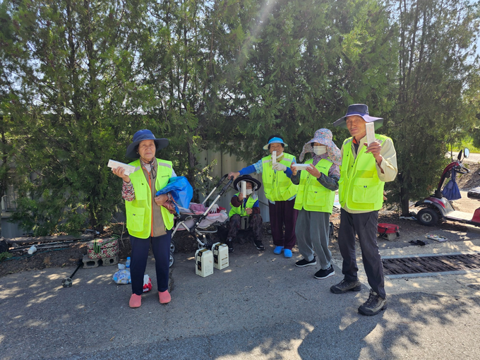 ▲ 의성시니어클럽이 지난 6월 경북 의성군 점곡면에서 ‘내고향물지킴이’ 사업단 어르신들에게 후원 물품을 전달한 뒤, 반장 김계선(왼쪽 첫 번째)을 비롯한 참여자들이 물품을 들고 기념촬영을 하고 있다. 의성군