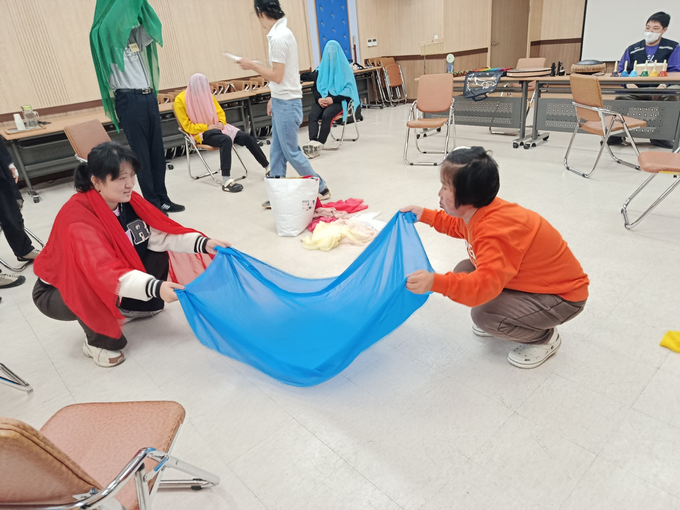 ▲ 의성군장애인보호작업장 이용자들이 22일 의성군종합복지관 대강당에서 색깔 천을 이용해 자신의 감정을 표현하는 활동을 하며 협동 동작을 맞추고 있다. 의성군장애인보호작업장