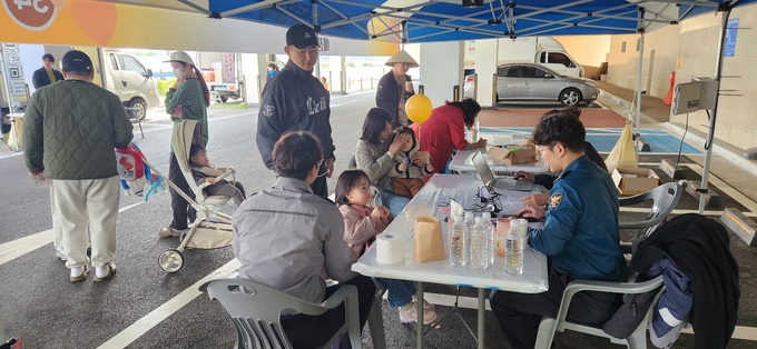 ▲ 예천경찰서 생활안전과 여성청소년 직원들이 25일 호명읍 복합커뮤니티센터 주차장에서 열린 제5회 예천군 복지박람회에 참가해 지문등 사전등록제 홍보와 현장 등록 서비스를 실시하는 장면, 예천경찰서 제공