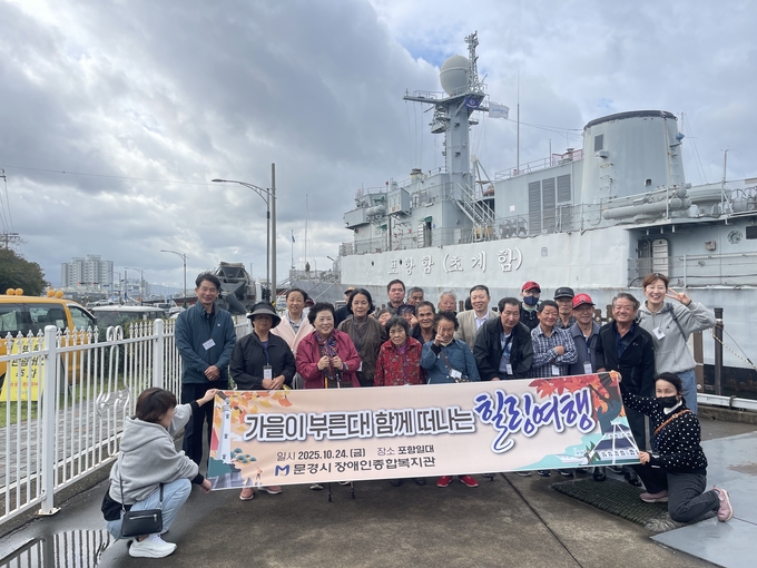 ▲ 문경시장애인종합복지관이 마련한 ‘가을이 부른다! 함께 힐랭여행’에 참여한 장애인들이 포항함 앞에서 기념촬영을 하고 있다.