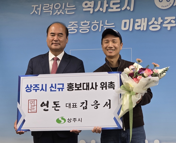 ▲ 돈가스의 장인으로 알려진 연돈 대표 김응서 대표(오른쪽)가 상주시 홍보대사로 위촉된 27일 강영석 상주시장과 함께 기념 촬영하고 있다. 상주시 제공