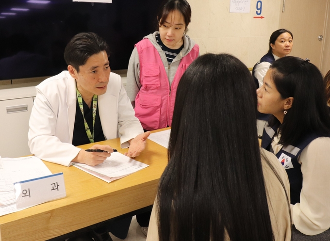 ▲ 구미순천향병원 김성호 교수(의료봉사단장)가  25일 본원 종합건강증진센터에서 외국인 근로자를 진료하고 있다.