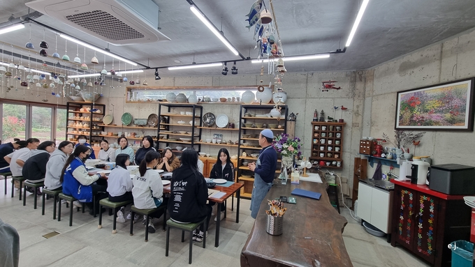 ▲ 탑리여자중학교 학생들이 24일 의성요 도자기공방 실습장에서 최해완 명장의 설명을 들으며 도자기 제작의 기본 공정을 배우고 있다. 의성교육지원청