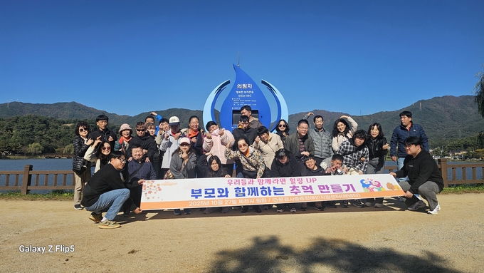 ▲ 의림지의 곧게 뻗은 소나무 숲길을 걸은 후 청풍호반 앞에서 기념찰영을 하는 참가자들.