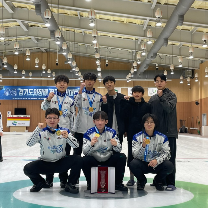 ▲ 의성중학교 컬링부 선수들과 관계자들이 27일 의정부컬링경기장에서 열린 제3회 경기도의장배 전국컬링대회 시상식 후 얼음판 위에서 금메달과 우승 트로피를 앞에 두고 주먹을 들어 올리며 단체 기념촬영을 하고 있다. 의성중