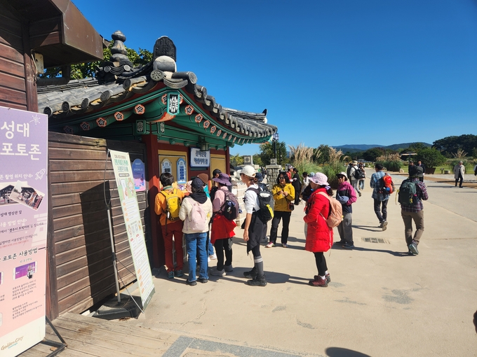 ▲ 첨성대 포토존 앞에 줄 선 관광객들이 안내문을 살펴보며 순서를 기다리고 있다.