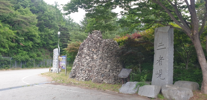 ▲ 삼자현 정상에 이르면 마주하게되는 삼자현 표지석과 돌탑. 한 때 이곳은 여행객들이 잠시 휴식하는 공간으로 인산인해를 이루기도 했다.