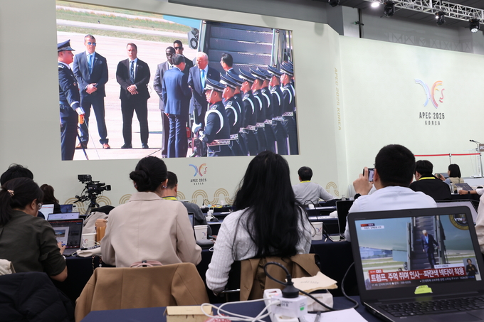 ▲ 29일 오전 경주APEC 국제미디어센터에 국내외 취재진들이 속속 자리한 가운데 각국에서 온 기자들이 트럼프 미국 대통령의 한국 도착 생중계 화면을 보고 있다. 김영환 기자 yhk@kyongbuk.com