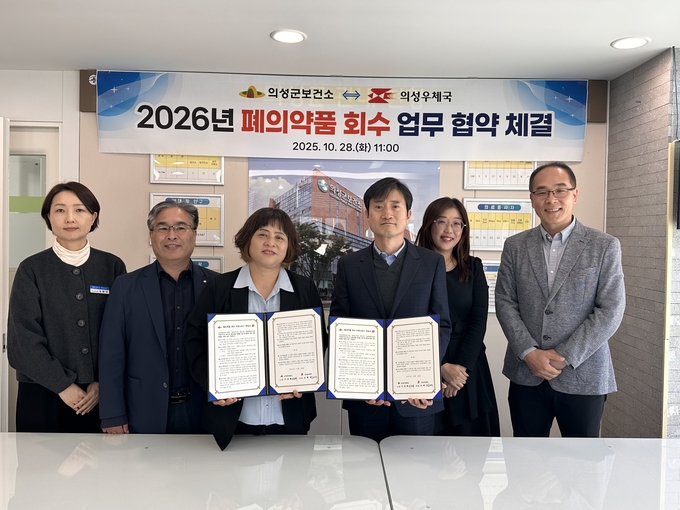 ▲ 이선희 의성군보건소장(왼쪽 셋째)과 조재식 의성우체국장(오른쪽 셋째)을 비롯한 양 기관 관계자들이 28일 의성군보건소 회의실에서 ‘2026년 폐의약품 회수 업무협약’을 체결한 뒤 협약서를 들고 기념촬영을 하며 정기 수거체계 구축을 다짐하고 있다. 의성군