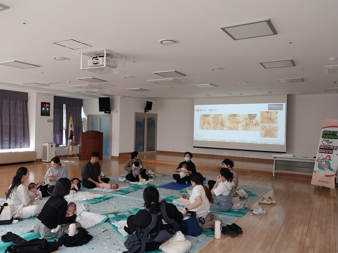 ▲ ‘마더스톡톡 엄마모임’ 참가자들이 베이비 마사지 교육을 받으며 웃음 짓는 모습.
