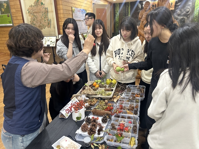 ▲ 포항중앙여고 학생들이 경상북도 수목원에서 전문가의 설명에 따라 각종 열매와 나뭇잎에 대해 공부하고 있다.