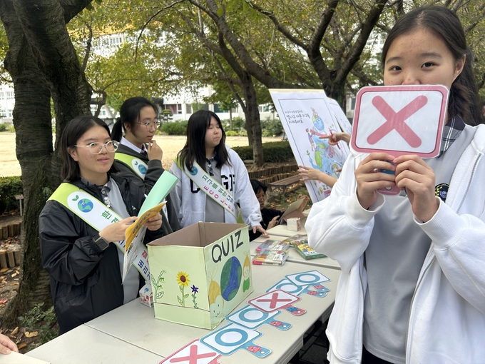 ▲ 포항중앙여고의 환경 동아리 학생들이 벚꽃길에서 탄소중립 실천 캠페인을 진행하고 있다.