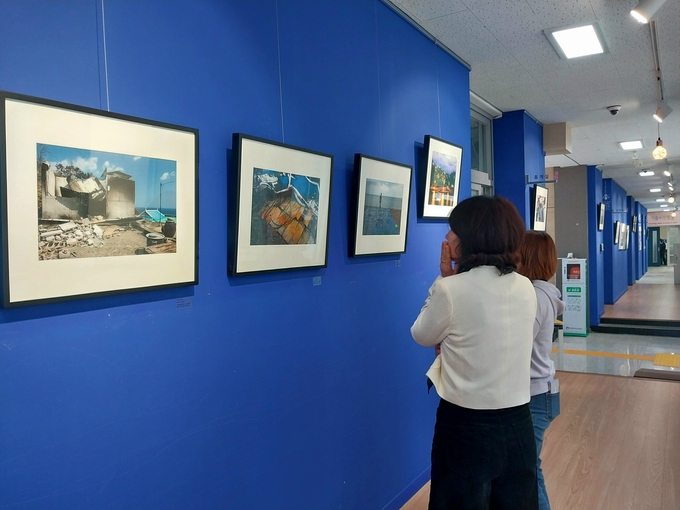 ▲ 영덕 병곡중학교 내 고래불 작은 미술관에서 30일 박정일 사진작가의 초청전 ‘순환의 영원을 기억하다’가 개막했다. 주민들이 전시 관람을 하고 있다.  최길동 기자