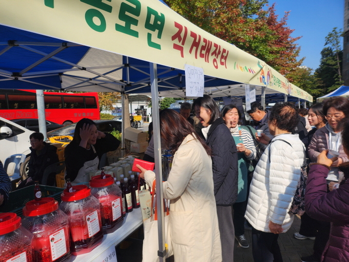 ▲ 서울 광진구 자양3동 직거래장터에서 문경 동로면 관계자들이 감홍사과와 오미자청 등 지역 농특산물을 판매하며 시민들과 소통하고 있다.