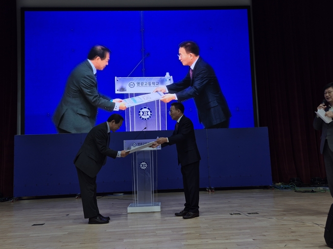 ▲ 영주 영광고 총동창회장 송호근 회장이 오성우 교장에게 장학금을 전달하고 있다.