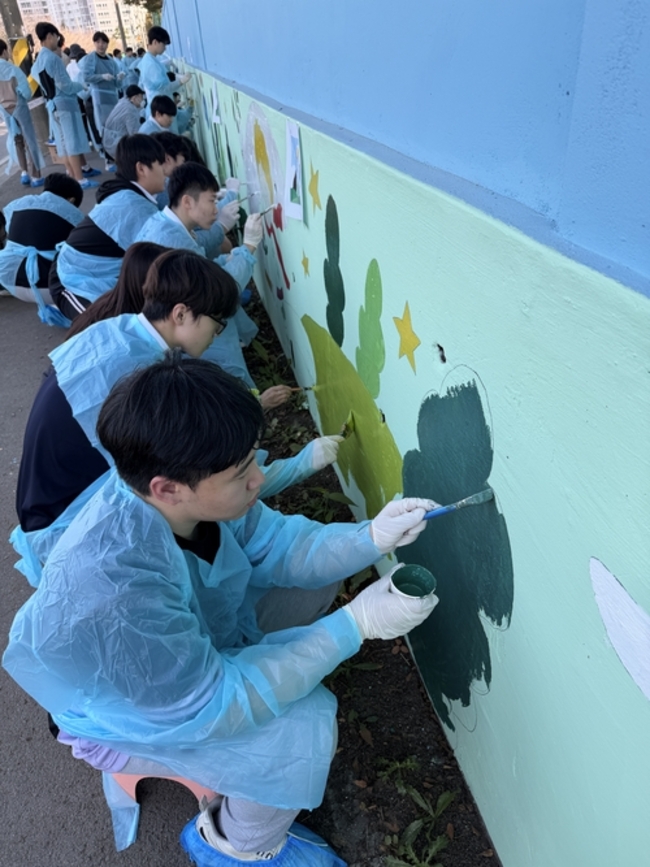 ▲ 구미고등학교 학생들이 초록별 아트스쿨회원들과 함께 구미칠곡축산물 유통센터 벽면에 벽화그리기 작업을 하고있다.
