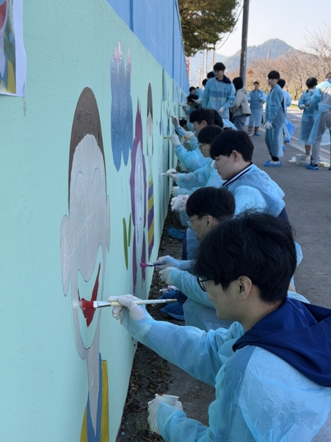 ▲ 구미고등학교 학생들이 초록별 아트스쿨회원들과 함께 구미칠곡축산물 유통센터 벽면에 벽화그리기 작업을 하고있다.