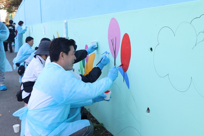 ▲ 구자근 국회의원이 구미고등학교 학생들과 초록별 아트스쿨 회원들과 함께 구미칠곡축산물유통센터 벽면에 벽화그리기에 참가해 색칠을 하고있다.