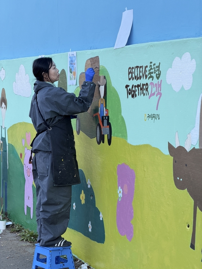 ▲ 초록별 아트스쿨회원이 구미칠곡축산물 유통센터 벽면에 벽화그리기 작업을 하고있다.