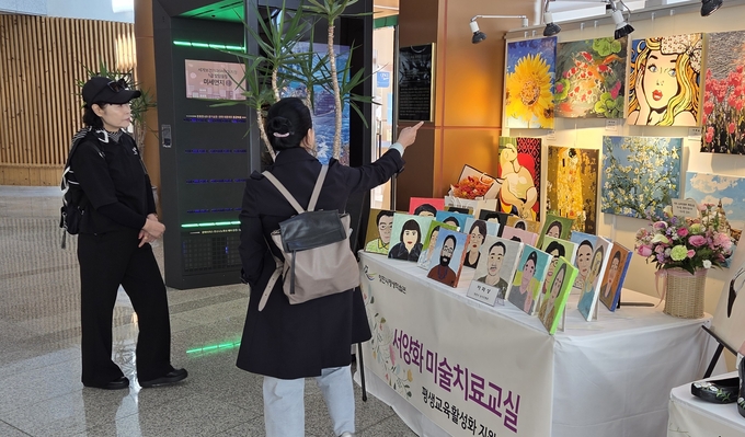 ▲ 지난 1일 시민들이 평생학습축제 작품 전시장에서 농아인들의 미술작품을 관람하고 있다. 권오석 기자
