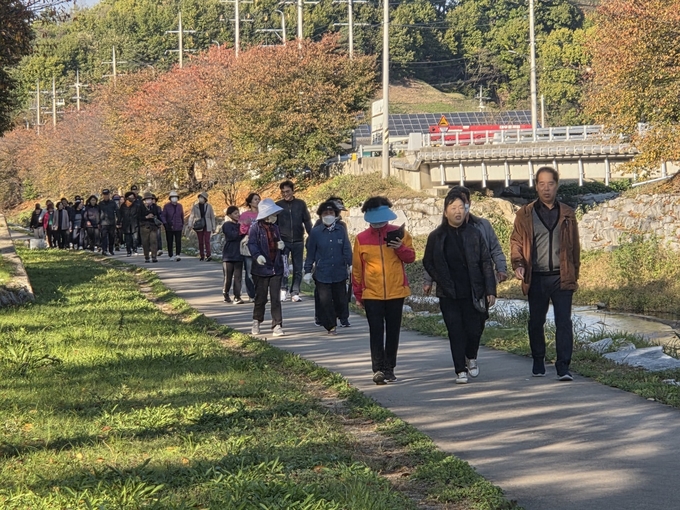 ▲ 영주시 휴천1동 주민자치위원회가 1일 동부초등학교 체육관과 원당천에서 ‘2025 휴천1동 어울림 마당’을 열고 있다. 시민들이 원당천을 걷고 있다.