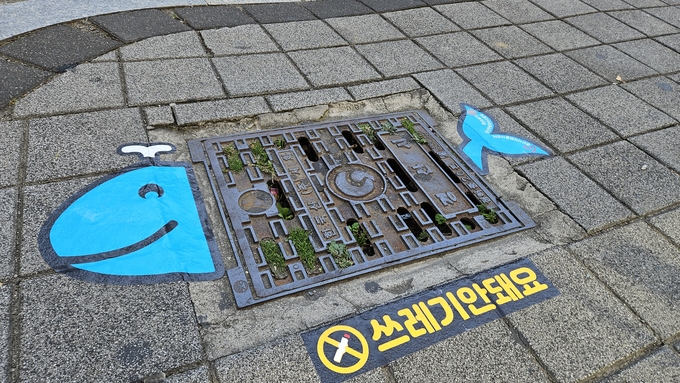 ▲ 경산시자원봉사센터는 지난 1일, 하양읍 중심 상권 일대에서 빗물받이 내 담배꽁초 무단투기를 근절하고 시민들의 환경 인식 개선을 촉구하는 ‘바다의 시작’ 캠페인을 실시했다. 바닥사인물 설치. 경산시.