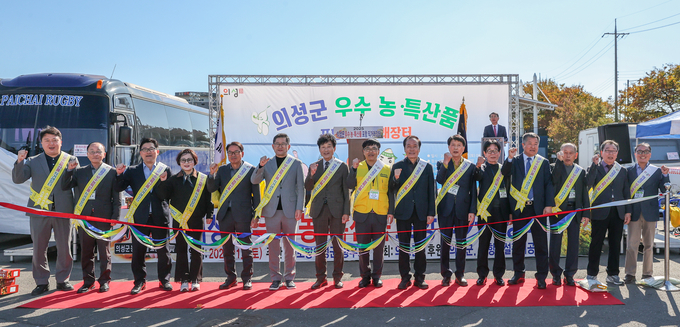 ▲ 1일 포항시 남구 포항야구장 서편주차장에서 열린 ‘2025 의성군 우수 농·특산품 포항 직거래장터’ 개장식에서 김기만 재포항의성군향우회장(왼쪽 여덟 번째)과 김주수 의성군수(아홉 번째)를 비롯한 참석자들이 테이프 커팅을 앞두고 주먹을 들어 행사의 성공을 다짐하고 있다. 의성군