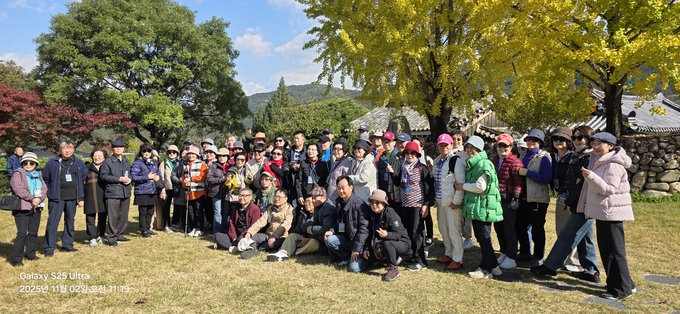 ▲ 재경 군위군 향우회원 90여 명이 2일 군위의 대표 전통마을 ‘한밤마을’에서  투어 중 기념촬영을 하고있다. 군위군