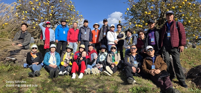▲ 재경 군위군향우회원들이 2일 대구 군위군 부계면에 있는  ‘사유원’ 모과나무 앞에서 기념촬영을 하고있다. 군위군
