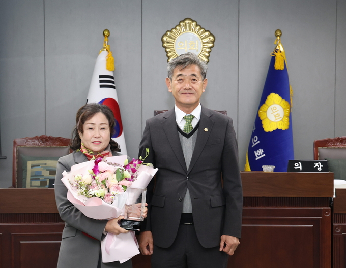 ▲ 김태이 의원이 청도군의회 전종율 의장에게 의정대상을 수여받고 기념촬영을 하고 있다.