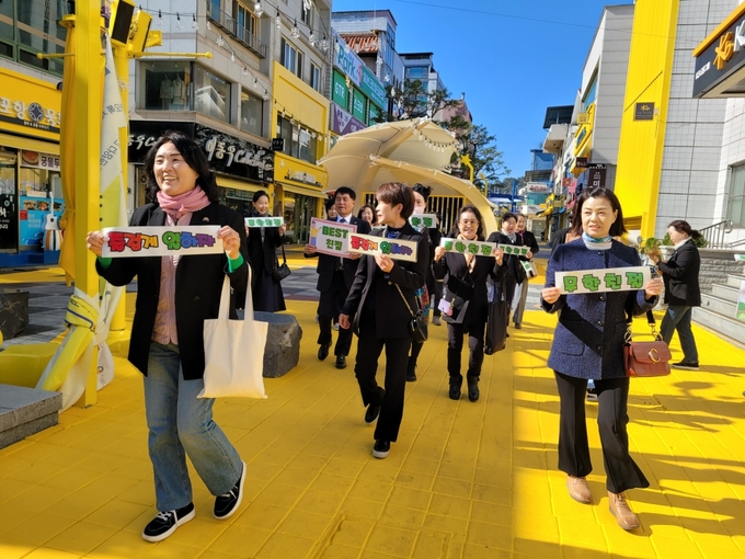 ▲ 문경 문화관광해설사들이 닻별거리 상점가 일대에서 ‘미소로 여는 친절 문경’ 캠페인을 진행하며 밝은 미소로 시민과 관광객에게 인사하고 있다.