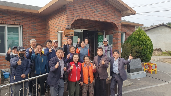 ▲ 의성군 봉양면 풍리2리 김선식 이장을 비롯한 주민들이 10월 30일 붉은 벽돌 마을회관 앞에서 김영훈 면장(앞줄 오른쪽 첫 번째), 김원석 군의원(두 번째)과 함께 ‘소각산불 없는 녹색마을’ 우수마을 현판식을 마친 뒤 불법소각 근절을 다짐하며 환한 미소로 엄지를 들어 보이고 있다. 의성군