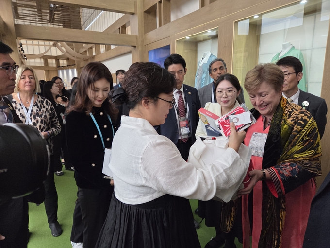 ▲ APEC경제전시장에서 IMF총재에게 해녀의 옷장을 소개하고 있다.