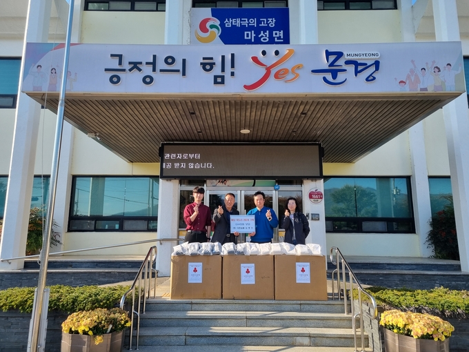 ▲ 김중진 대흥숯불 대표(왼쪽 두번째)가 4일 마성면행정복지센터를 방문해 방한용 패딩 목도리 200개를  이혜동 마성면장(오른쪽에서 두번째)에게 전달하고 있다.