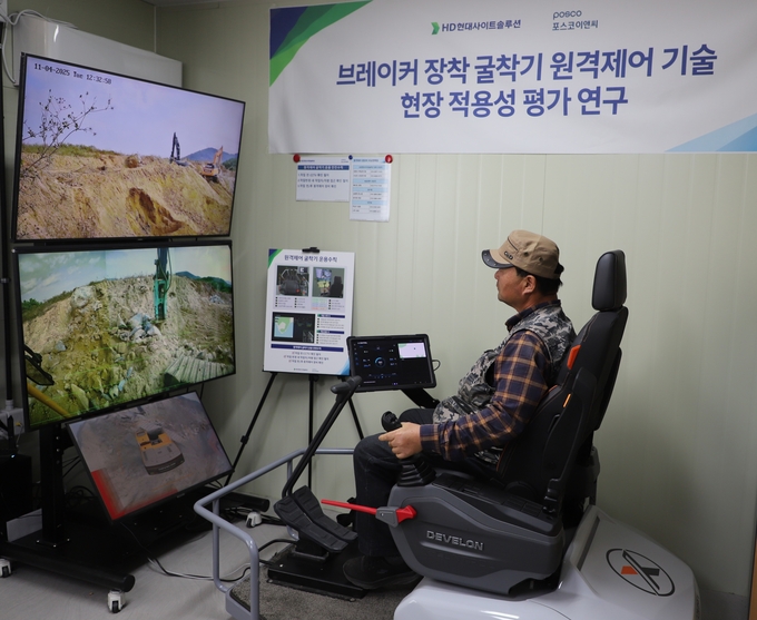 ▲ 포스코이앤씨와 HD현대사이트솔루션이 공동개발한 무인원격 굴착기를 개발, 연수 화태-백야간 도로건설 현장  실증작업에서 원격조종하고 있는 모습.