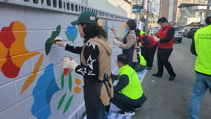 ▲ 구미의 핫플 금리단길에 김낙관 구미시의원과 법무부 구비보호관찰소 협의회 회원들이 함께 벽화를 그리고있다. 이봉한기자