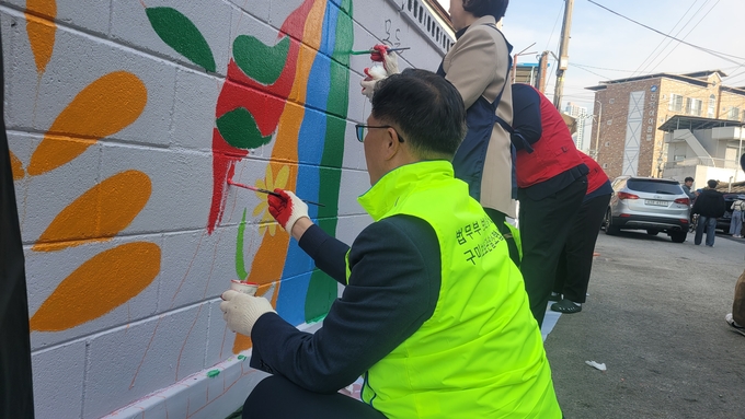 ▲ 구미시의회 김낙관 산업건설위원장이 금린단길 벽화에 색칠을 하고있다. 이봉한기자