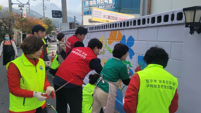 ▲ 구미시 금리단길 벽면에 법부무 구미보호관잘소 협의회원들과 국민의힘 구미갑 미래세대 청년위원들이 벽화를 그리고 있다. 이봉한기자
