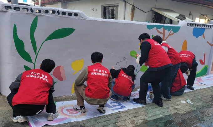 ▲ 국민의힘 구미갑 당협 미래세대위원회가 금리단길 벽화에 그림을 그리고 있다. 이봉한기자