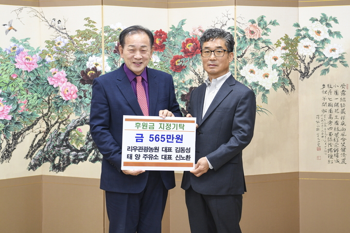 ▲ 지난 5일 리우관광농원 김동성 대표(오른쪽)가 신현국 문경시장에게 농암면 지역사회보장협의체에 후원금 565만 원을 전달한 뒤 기념촬영을 하고 있다.