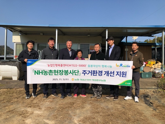 ▲ 농협 의성군지부 이진석 지부장(왼쪽 여섯 번째)과 의성중부농협 신동환 조합장(세 번째)을 비롯한 임직원들이 5일 경북 의성군 안평면 창포길 일대 돌봄 어르신 가구 앞에서 ‘NH농촌현장봉사단 주거환경 개선 지원’ 활동을 진행하며 현수막을 들고 기념촬영하고 있다. 농협 의성군지부