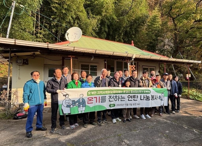 ▲ 호계면 지역사회보장협의체와 문경시황씨청년회 회원들이 부곡리 일원에서 어려운 이웃에게 연탄을 직접 나룬 후 기념촬여을 하고 있다.