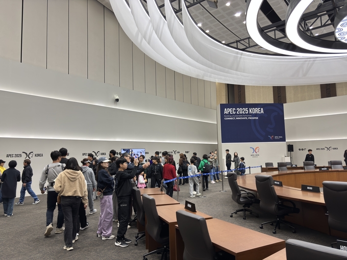 ▲ 지난 9일 경주화백컨벤션센터 3층 APEC 본회의장에서 시민들이 실제 정상회의 때 사용된 의자와 단상, 국기, 명패 등이 그대로 유지된 회의장 내부를 둘러보고 있다. 경주시