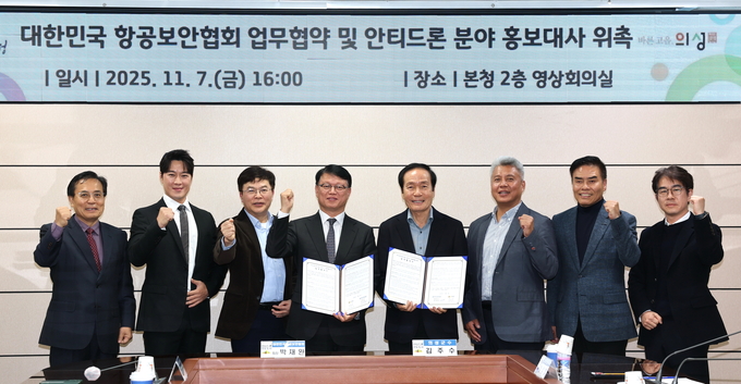 ▲ 11월 7일 의성군청 영상회의실에서 열린 ‘대한민국 항공보안협회 업무협약 및 안티드론 분야 홍보대사 위촉식’에서 박재완 항공보안협회장(왼쪽 네 번째)과 김주수 의성군수(왼쪽 다섯째)가 협약서를 들고 참석자들과 함께 기념촬영을 하고 있다. 의성군