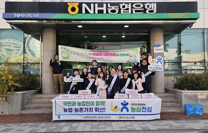 ▲ 11일 농협영천시지부 직원들이 지부 앞에서 농업인의날 기념 ‘가래떡 데이’ 행사를 가지며 기념촬영을 하고 있다. 농협영천시지부 제공